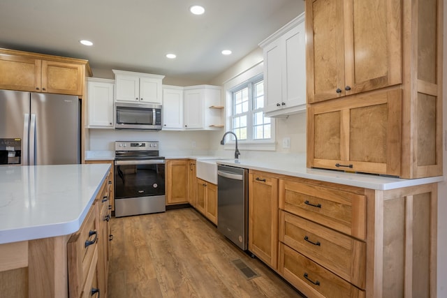 kitchen with visible vents, light wood-style flooring, appliances with stainless steel finishes, open shelves, and a sink