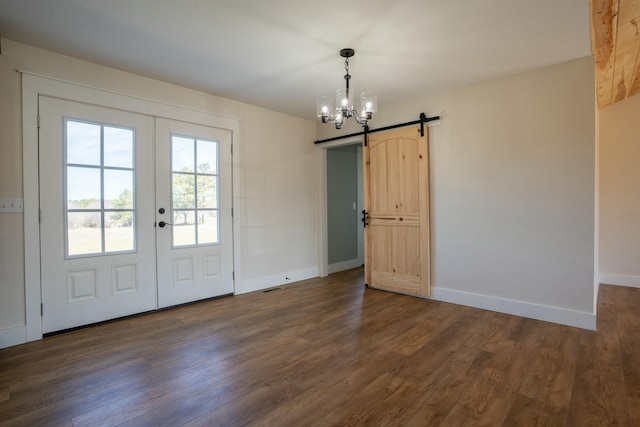 interior space featuring dark wood-style flooring, french doors, baseboards, and a barn door