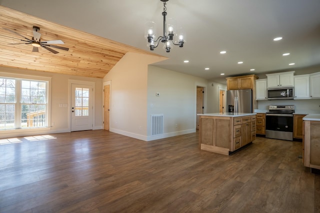 kitchen with lofted ceiling, visible vents, appliances with stainless steel finishes, a center island, and dark wood-style floors