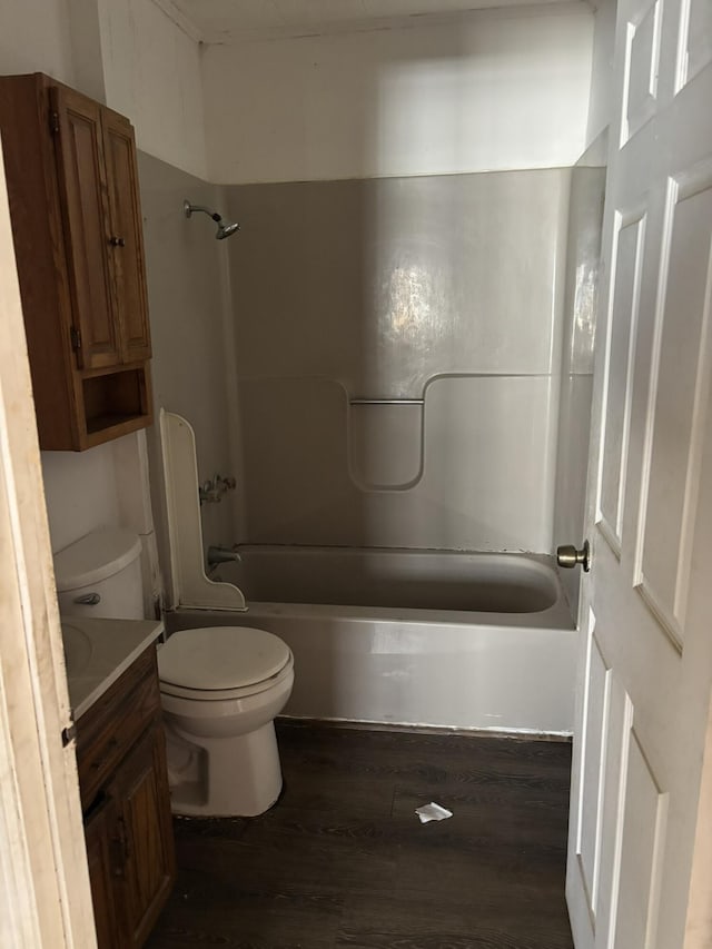 bathroom featuring toilet, shower / tub combination, wood finished floors, and vanity