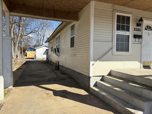 view of home's exterior featuring concrete driveway and cooling unit