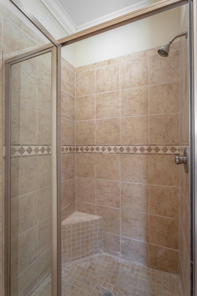 bathroom with a shower stall and crown molding