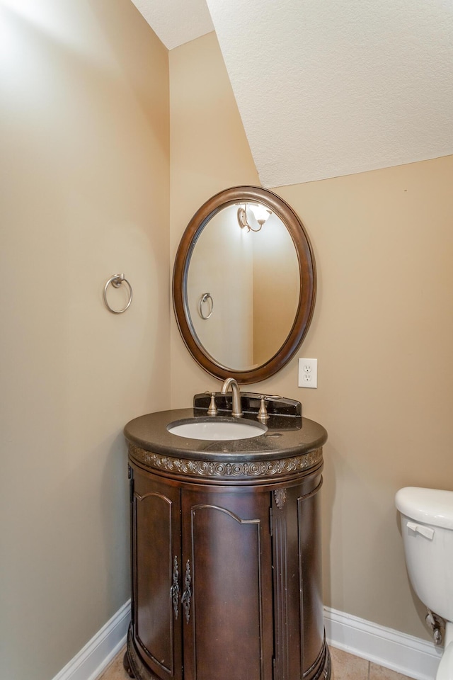 half bath with vanity, baseboards, and toilet