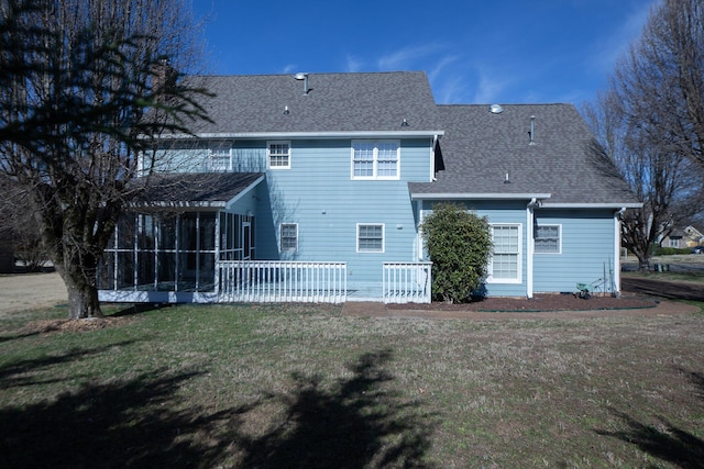 rear view of property featuring a sunroom, roof with shingles, and a yard