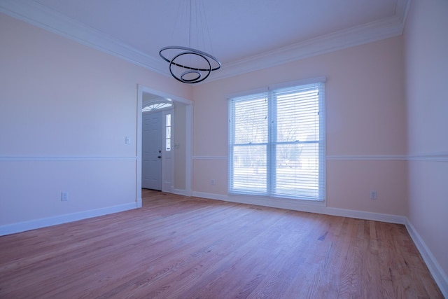 spare room featuring ornamental molding, wood finished floors, and baseboards