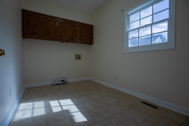 laundry area featuring washer hookup, visible vents, cabinet space, and baseboards