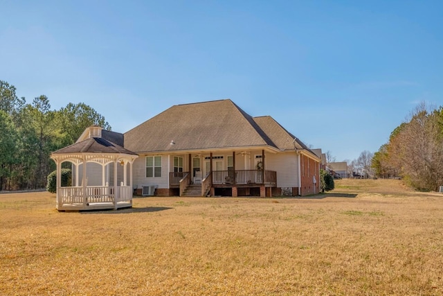 rear view of property featuring a yard, central air condition unit, a gazebo, a ceiling fan, and a wooden deck