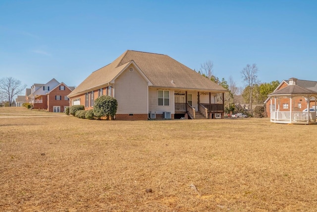 rear view of property featuring covered porch, a gazebo, a lawn, and central air condition unit