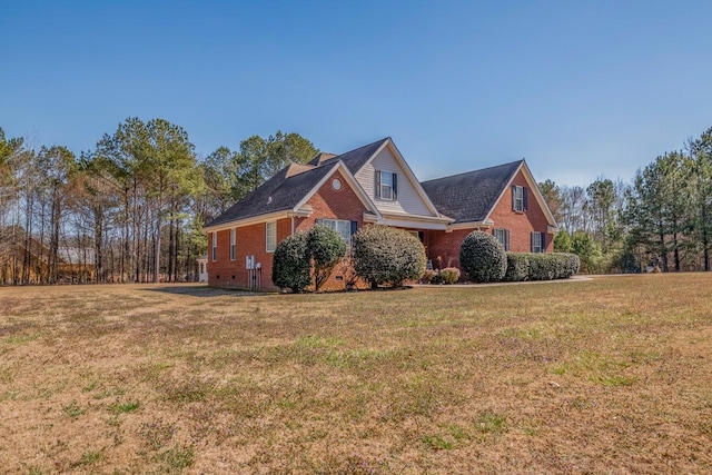 view of side of property with brick siding and a lawn