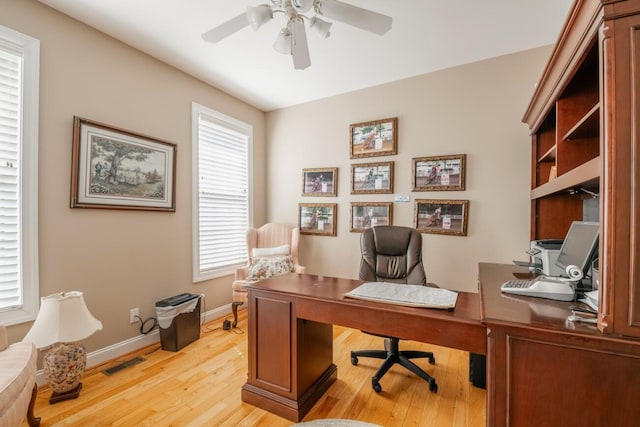 office area featuring baseboards, visible vents, ceiling fan, and light wood finished floors