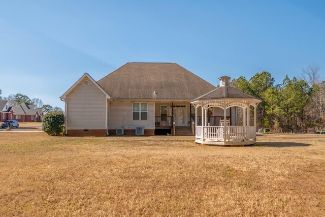 back of property featuring roof with shingles, crawl space, a gazebo, a yard, and central AC