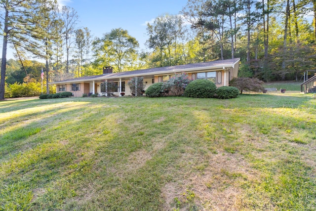 ranch-style home featuring a chimney and a front yard