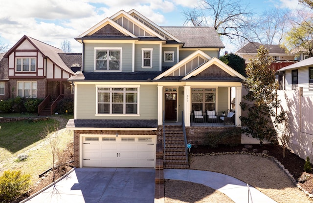 view of front of home featuring stairway, a porch, an attached garage, concrete driveway, and brick siding