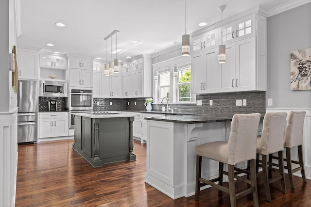 810 Boylston St, Chattanooga, TN 37405 - kitchen featuring appliances with stainless steel finishes, white cabinetry, a peninsula, ornamental molding, and glass insert cabinets