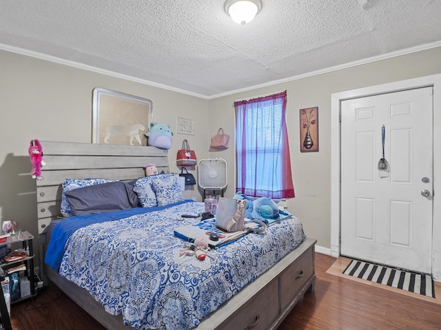 bedroom with a textured ceiling, ornamental molding, and wood finished floors