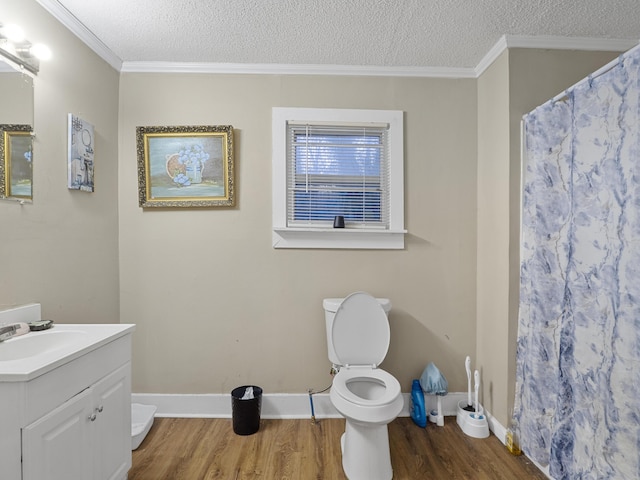 bathroom with ornamental molding, a textured ceiling, toilet, and wood finished floors