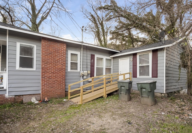 view of home's exterior featuring brick siding and a wooden deck