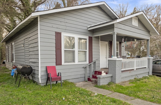 bungalow with a porch and a front lawn