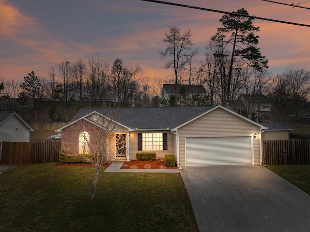 ranch-style home featuring a garage, fence, a lawn, and concrete driveway