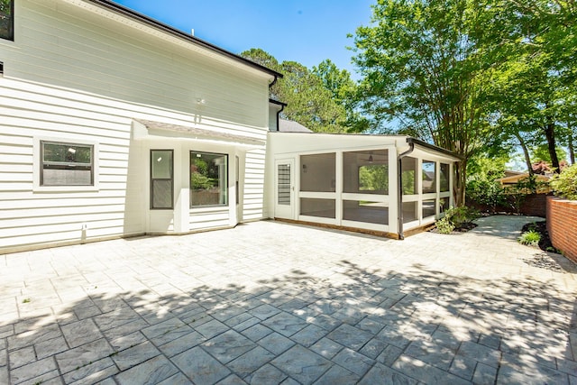 back of property with a sunroom, a patio area, and fence