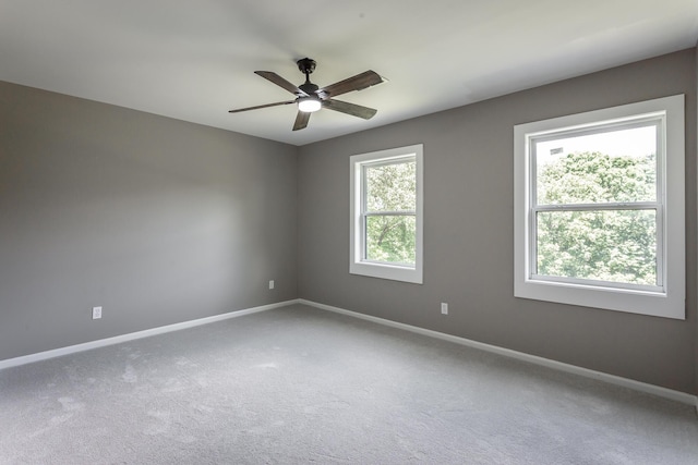 carpeted empty room with baseboards and a ceiling fan