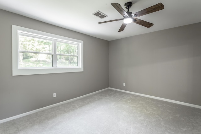 carpeted empty room with visible vents, ceiling fan, and baseboards