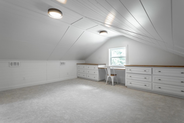 additional living space featuring lofted ceiling, visible vents, and light colored carpet