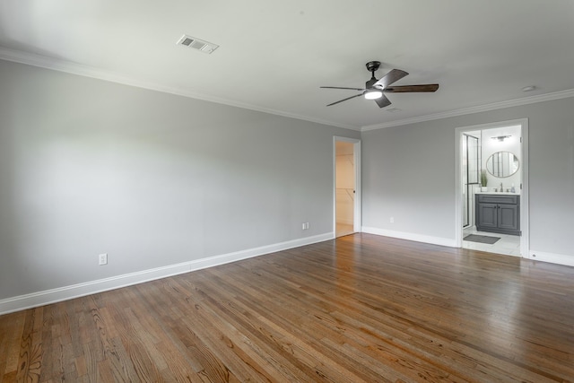 unfurnished room featuring baseboards, crown molding, visible vents, and wood finished floors