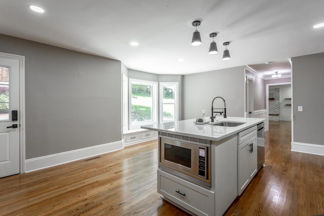 kitchen featuring light wood finished floors, appliances with stainless steel finishes, a sink, and visible vents