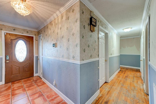 foyer entrance with ornamental molding and a textured ceiling