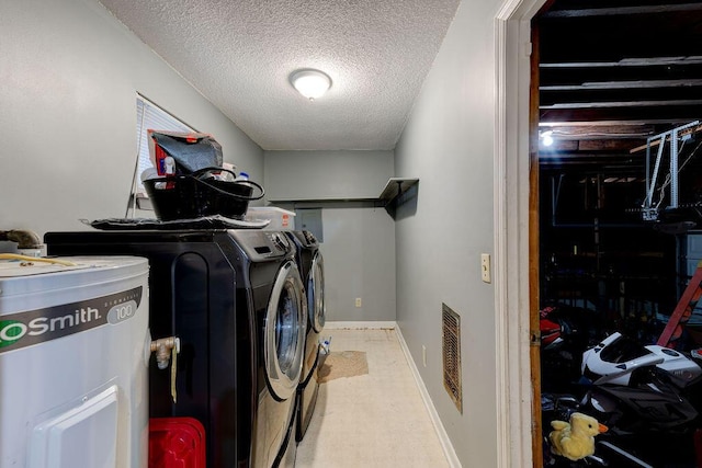 clothes washing area featuring baseboards, a textured ceiling, visible vents, and washer and dryer