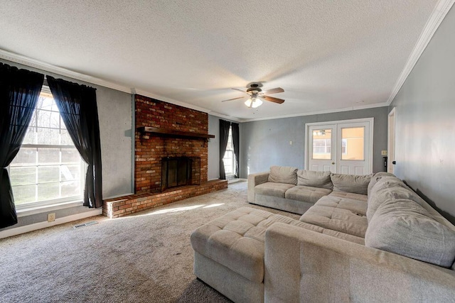 carpeted living area with visible vents, ceiling fan, ornamental molding, a textured ceiling, and a brick fireplace