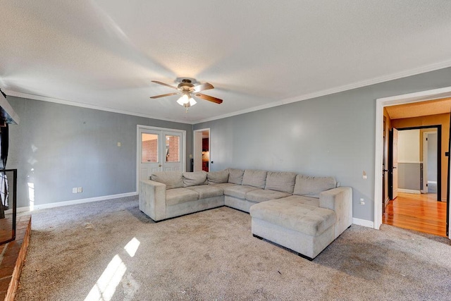 carpeted living room featuring a ceiling fan, ornamental molding, and baseboards