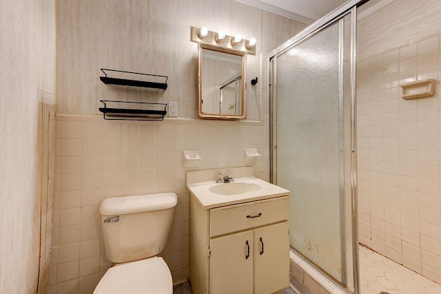 full bathroom with toilet, a stall shower, vanity, and tile walls