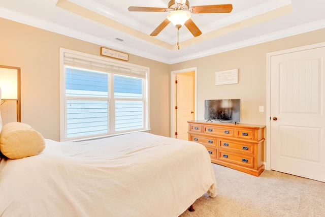 bedroom featuring light carpet, a raised ceiling, and crown molding