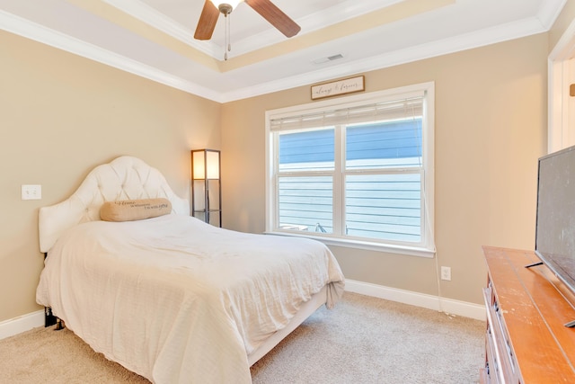 carpeted bedroom featuring baseboards, a raised ceiling, visible vents, and crown molding