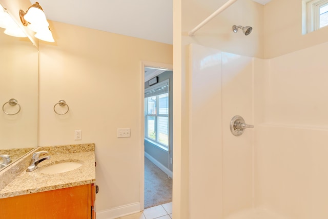 full bathroom with baseboards, a shower, a wealth of natural light, and vanity