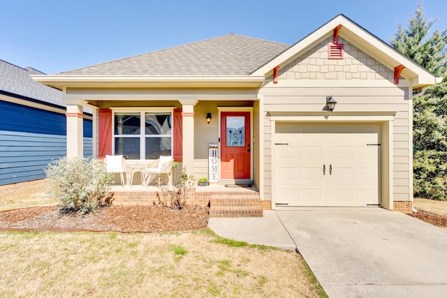 view of front facade with a porch, driveway, a shingled roof, and an attached garage