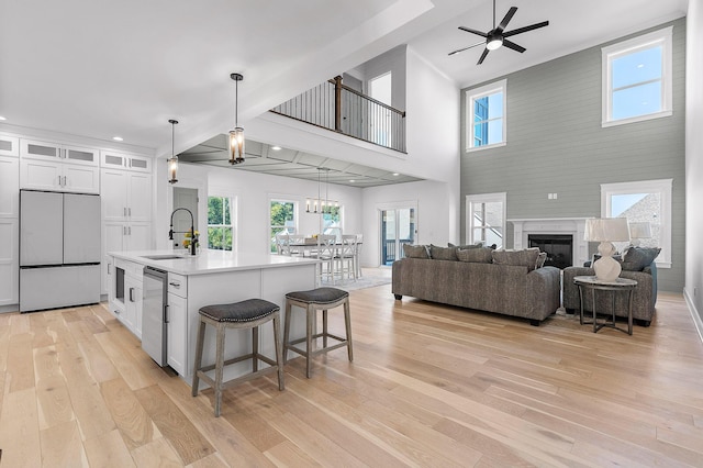 kitchen featuring open floor plan, a sink, light wood-style flooring, and built in refrigerator