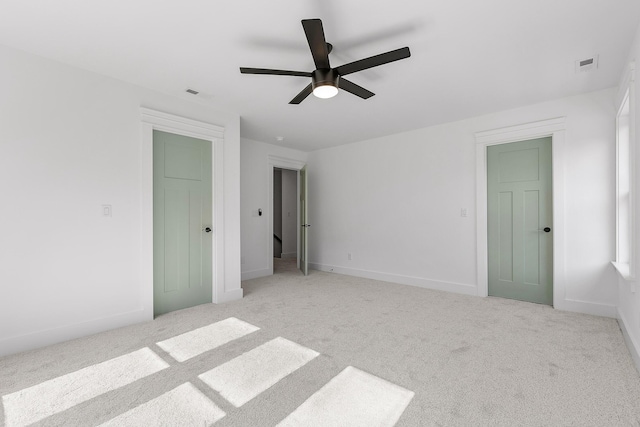 unfurnished bedroom with ceiling fan, carpet floors, visible vents, and baseboards