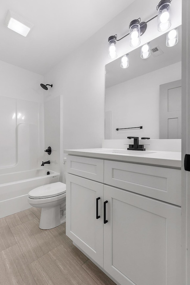 bathroom featuring toilet, visible vents,  shower combination, and vanity