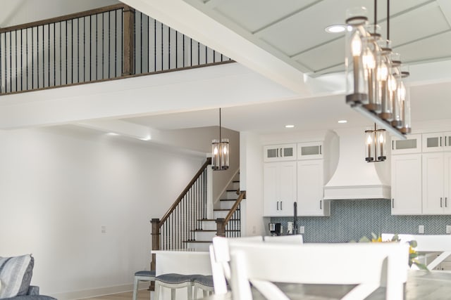 kitchen featuring white cabinets, custom range hood, decorative backsplash, and beam ceiling