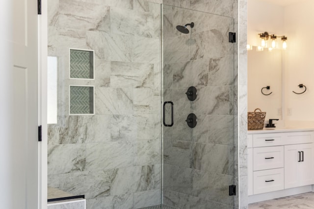 bathroom featuring a stall shower, marble finish floor, and vanity