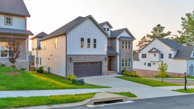9891 Trestle Cir Unit 48, Ooltewah, TN 37363 - view of front of house with board and batten siding, driveway, brick siding, a yard, and an attached garage