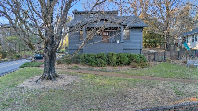 view of side of home with fence and a lawn