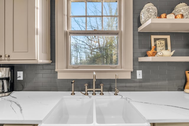 kitchen featuring a healthy amount of sunlight, a sink, decorative backsplash, and open shelves