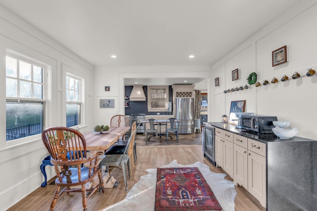 dining area featuring light wood-style flooring, wine cooler, and recessed lighting