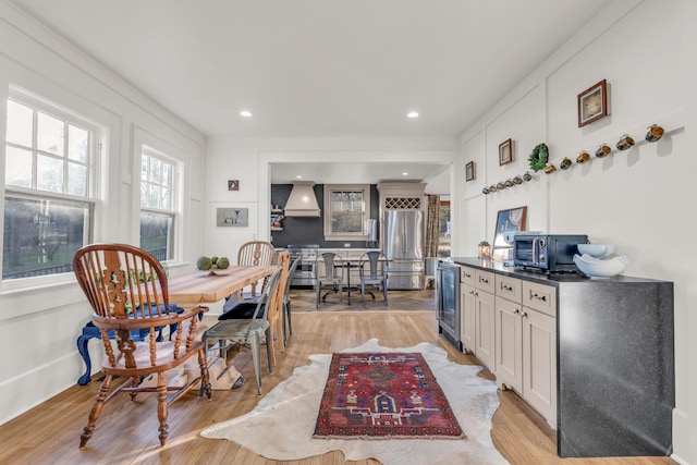 dining space featuring light wood-style floors, wine cooler, and recessed lighting