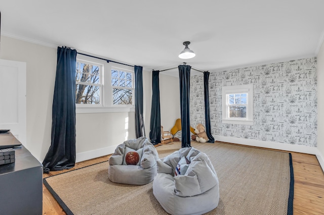 sitting room with ornamental molding, wood finished floors, and baseboards