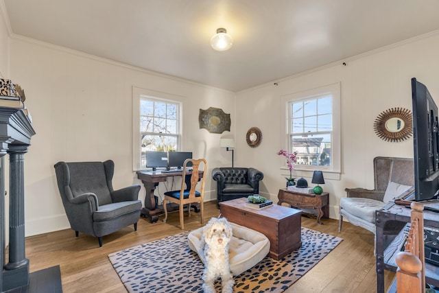 living area with ornamental molding, baseboards, and hardwood / wood-style floors